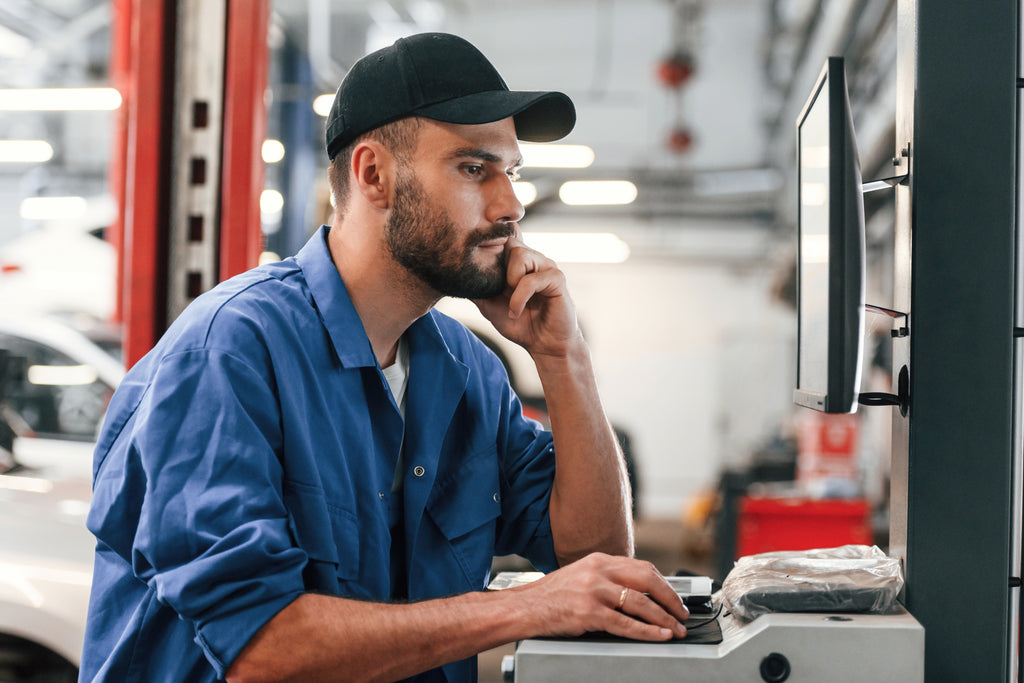 Mechanic using a computer in a workshop setting